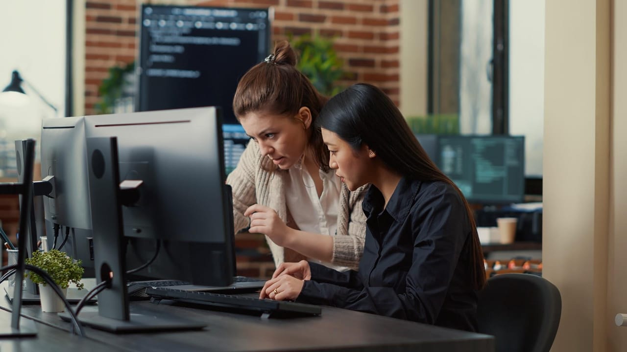 Two developers reading the same screen together, one pointing at the code.